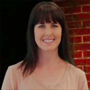 Smiling woman with shoulder-length dark hair and bangs